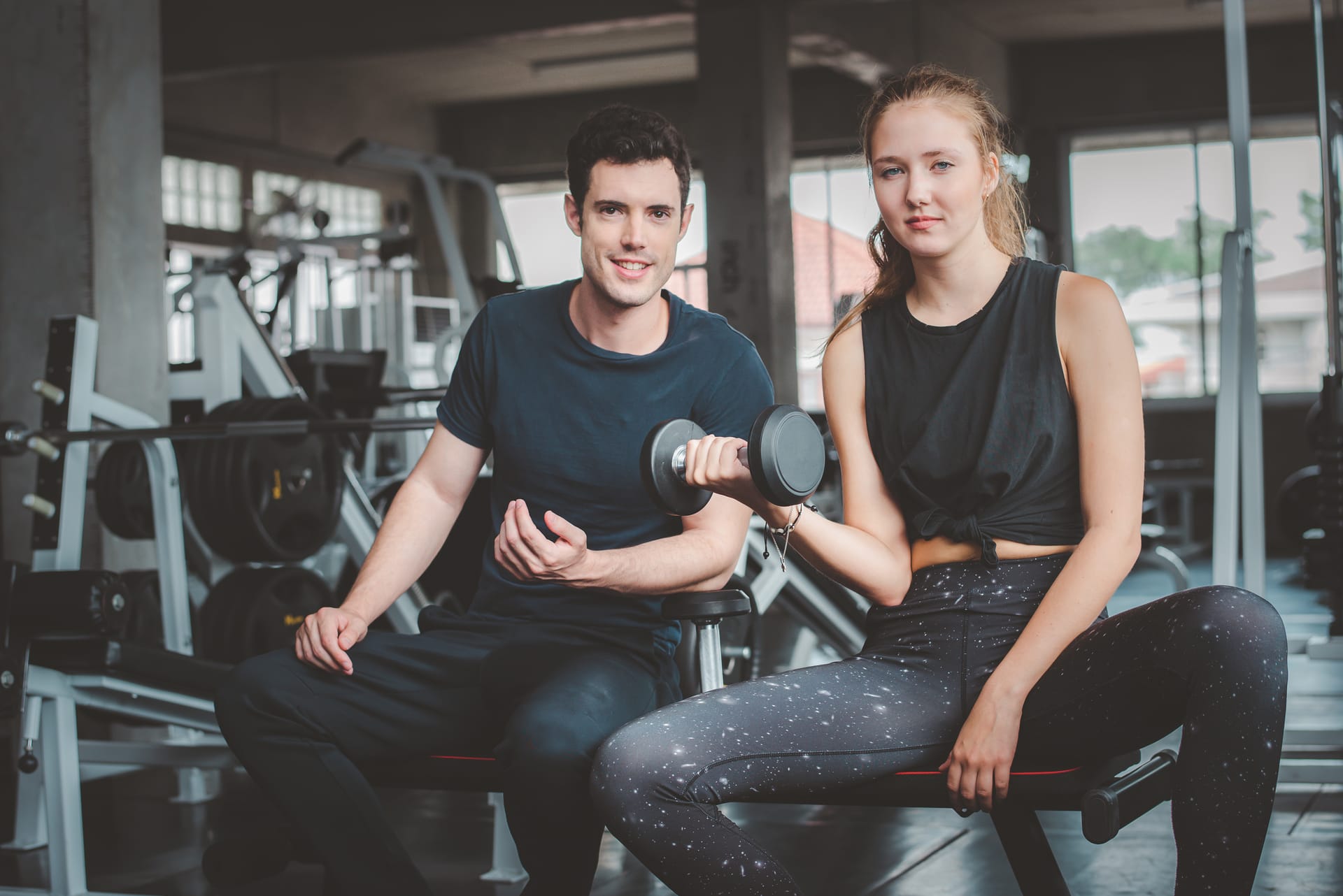 Caucasian couple on the bench in fitness gym Caucasian couple on the bench in fitness gym
